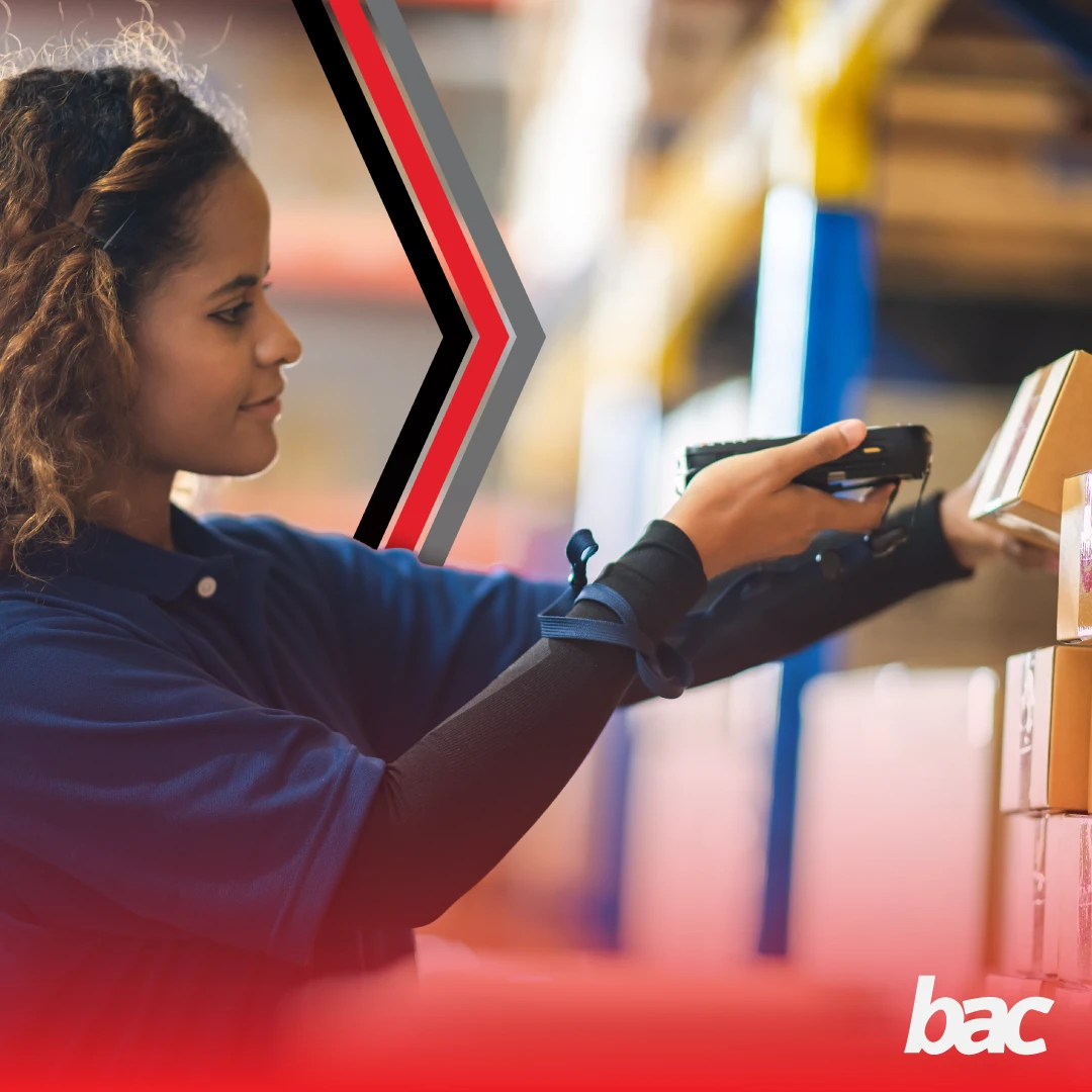 Warehouse worker scanning boxed inventory with a handheld barcode scanner (BAC)