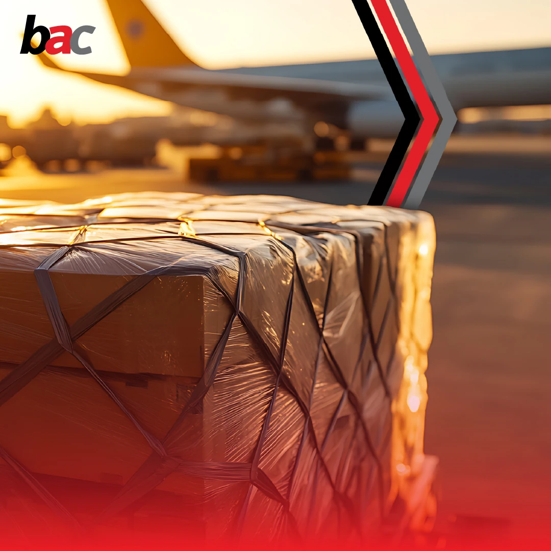 Air freight cargo pallet on airport tarmac at sunset with aircraft in background (BAC)