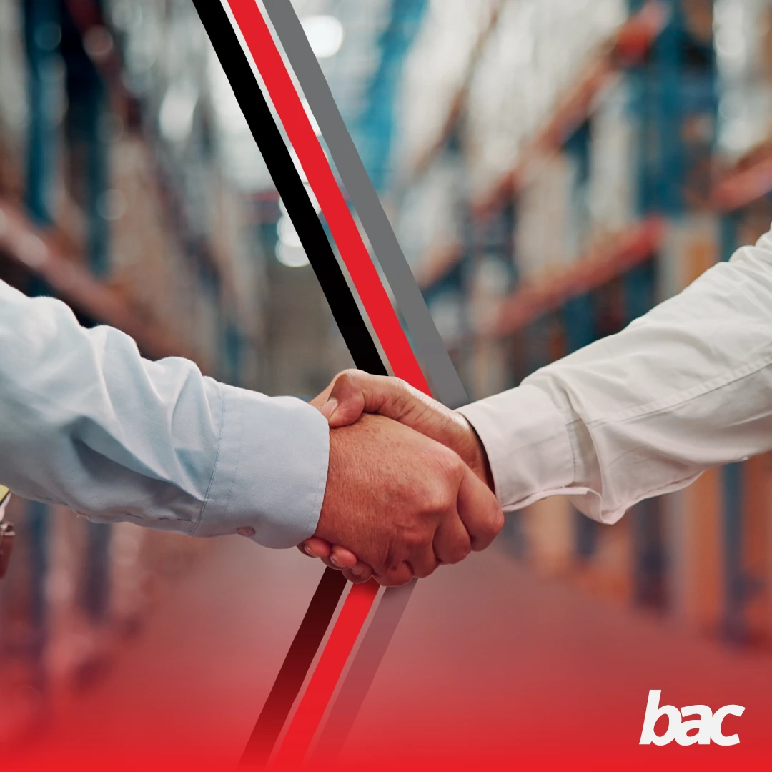 Two business professionals shaking hands in a warehouse